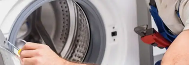 Appliance technician repairing a clothes dryer drum and internal parts in Kansas City, MO