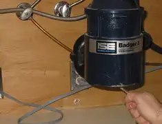 Garbage disposal repair technician tightening the mounting ring under a sink in Kansas City, MO