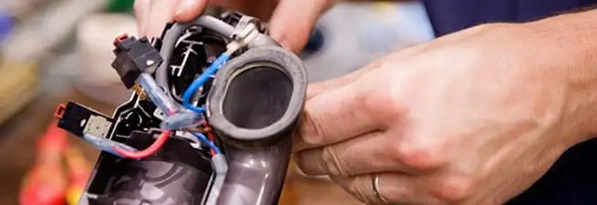 Vacuum repair technician reconnecting wiring and components in Kansas City, MO