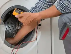 Washing machine repair technician testing a front-load washer with diagnostic tools in Kansas City, MO