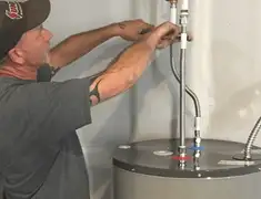 Water heater repair technician tightening supply line connections in Kansas City, MO